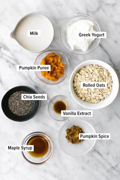 ingredients to make pumpkin spice oatmeal in bowls on a marble countertop