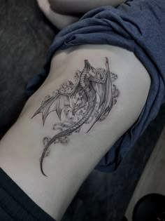 a woman's arm with a dragon tattoo on the left side of her body