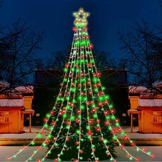 a lighted christmas tree in front of a building