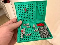 a person holding a green box filled with lots of screws