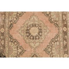 an antique rug with brown and beige colors on the bottom, it has a medallion design in