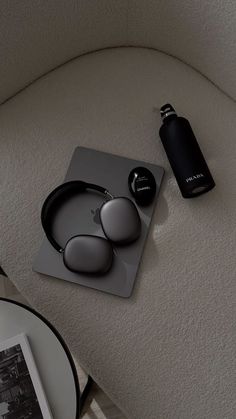 an ipod and headphones are sitting on a table next to a black water bottle