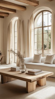 Rustic wooden coffee table in a bright living room with white sofas, large windows, and warm sunlight creating a cozy Light Beige Curtains, Modern Earthy Home Decor, Wooden Side Tables, Earthy Living Room, Beige Curtains, Rustic Coffee Table, Minimalist Inspiration, Cozy Spaces