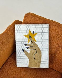 a close up of a tiled wall with a hand holding a star