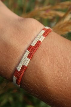 a red and white bracelet on someone's arm