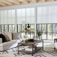 a living room filled with furniture and lots of windows