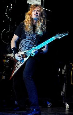 a woman with long hair playing an electric guitar