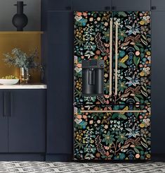 a kitchen with blue cabinets and floral wallpaper on the door, along with a coffee maker