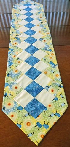 a blue and white tie sitting on top of a wooden table next to a wall