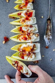 a person is reaching for some kind of appetizer with toppings on it