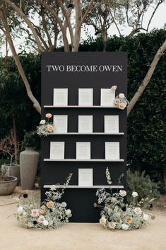 there is a sign that says two become own with flowers and cards attached to it