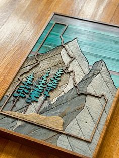 an art piece is displayed on a wooden table