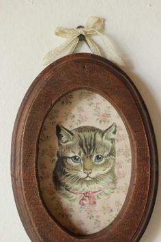 a cat in a wooden frame hanging on the wall