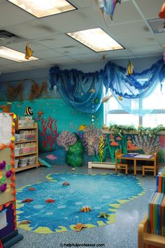 an ocean themed classroom with fish and corals on the walls, bookshelves and desks