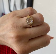 a woman's hand wearing a ring with an oval shaped stone in the middle