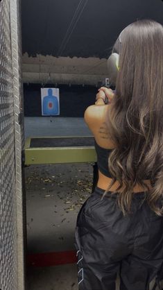 a woman with long hair taking a shot