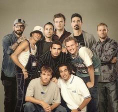 a group of men standing next to each other in front of a gray background with the words friends forever written on it