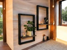 a living room with wood paneled walls and two black framed shelves on the wall