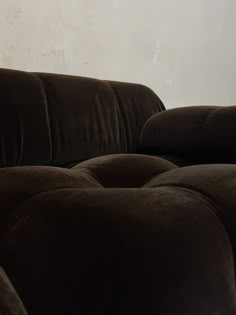 a brown couch sitting in front of a white wall