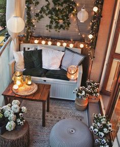 an outdoor balcony with lights and potted plants