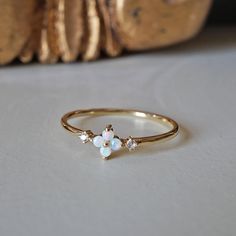 This dainty Forget Me Not ring features four natural Australian opal hugged between two natural diamonds. Set on a polished dainty band. A beautiful ring to wear on your finger to remind you of the beauty of life. Crafted in 14K solid gold in our NYC studio. 14K solid gold Natural Australian opals and diamonds 1.2mm ring band ** This item is specially made for you. Please allow 1-2 week lead time. Shipping:Domestic: Free standard shipping within the U.S.International: Free standard shipping for