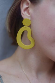 This is a pair of large statement earrings in a beautiful marigold yellow. *Please note because this color is hand mixed, slight variation occurs from batch to batch. Your particular pair of earrings may look slightly different from what is pictured, but that's because it's a unique handmade item made specially for you! These earrings are crafted using polymer clay, a surprisingly lightweight material that won't weigh you down. Each earring is carefully sanded and smoothed to ensure a well-made Modern Yellow Dangle Earrings, Modern Handmade Yellow Jewelry, Trendy Yellow Earrings For Everyday, Trendy Yellow Everyday Earrings, Yellow Earrings With Ear Wire For Everyday, Everyday Yellow Earrings With Ear Wire, Bold Yellow Drop Earrings, Trendy Yellow Earrings, Modern Yellow Earrings For Everyday