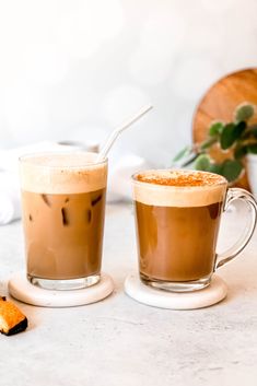 two cups of coffee sitting on top of a table