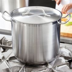 a large pot sitting on top of a stove next to a cutting board and knife