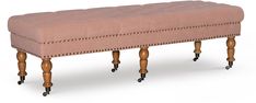 an upholstered bench with wooden legs and wheels on the bottom is shown in front of a white background