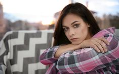 a woman with her arms crossed sitting on a couch