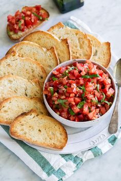 a white bowl filled with salsa next to sliced bread