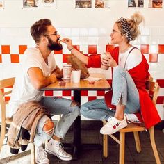 a man and woman sitting at a table eating food