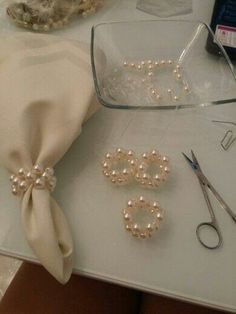 the table is set up with pearls, scissors and other crafting supplies on it