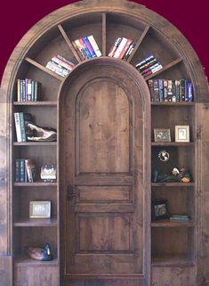 an arched wooden door with books on shelves