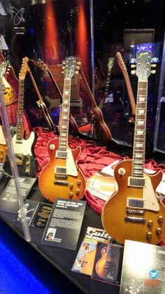 guitars are on display in a glass case