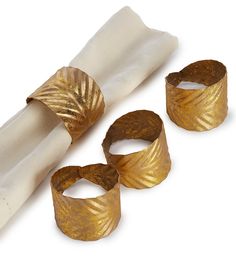 three gold napkin rings sitting next to each other