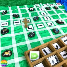 a green table topped with lots of different types of magnets on top of a checkered blanket