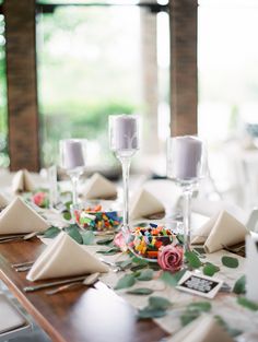 the table is set with place settings, candles and napkins for guests to sit at