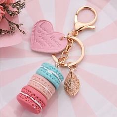 a pink heart shaped keychain sitting on top of a white and pink table