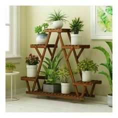 a wooden shelf filled with potted plants next to a window