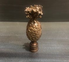 a gold pineapple shaped vase sitting on top of a table