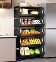 a metal refrigerator freezer sitting next to a shelf filled with fruits and veggies