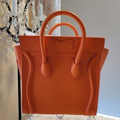 This Orange Handbag Or Tote Bag Has The Same Orange Coloring Similar As The Herms Orange. This Amazing Orange Color Will Coordinate With Any Fashionable Wardrobe. The Spacious Inside Is Incredible. Can Be Used As A Tote Bag Being The Bag's Size Or Just A Handbag. Zipper Closure And A Zipper Pocket Inside. A Small Zipper Pocket On The Front. Height: 10 Length :10 Depth: 5 The Bag Is New With Tags Never Used. I Did Find A Marking Near The Top Zipper Circled In Red. Included Dustbag Designer Orange Bags With Top Carry Handle, Luxury Orange Bags With Top Carry Handle, Orange Top Handle Bag With Dust Bag, Designer Orange Rectangular Bags, Designer Orange Rectangular Bag, Orange Top Handle Shoulder Bag With Dust Bag, Designer Orange Tote Shoulder Bag, Luxury Orange Handheld Bag, Luxury Handheld Orange Bag