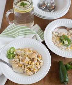 two white plates topped with food next to green peppers