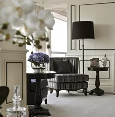 a living room filled with furniture and flowers in vases on top of a table