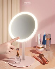 a person is pointing at the mirror on top of a table