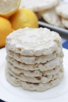 a stack of cookies sitting on top of a white plate with lemons in the background