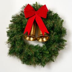 a christmas wreath with two bells hanging from it