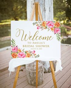 a welcome sign on an easel for a bridal shower