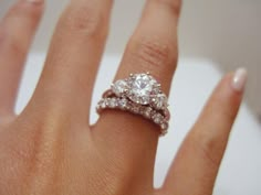 a woman's hand with two diamond rings on it